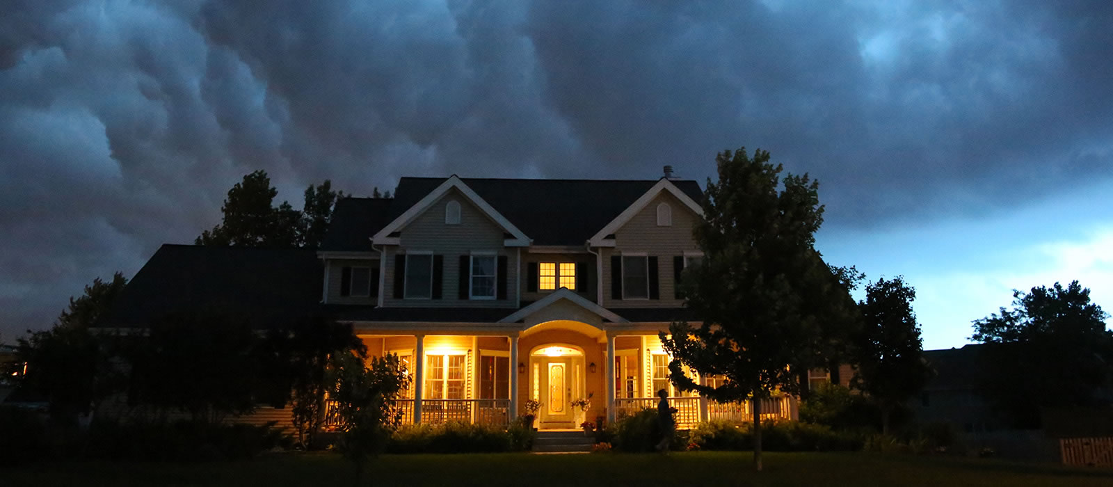 Image of a house at night, in a lightning storm, with its power still on